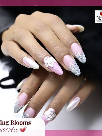 A beautiful example of bridal or formal nail art. This design features a soft, pearlescent base with intricate, hand-sculpted white flowers on almond-shaped nails, offering a look of pure elegance.