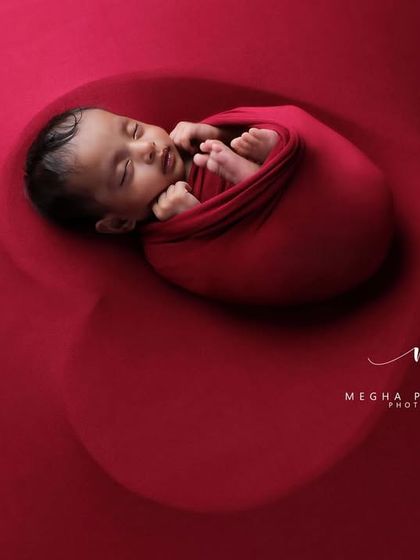 A slightly different angle, showing the baby peacefully sleeping. The contrast between the red and the white petals is visually striking.