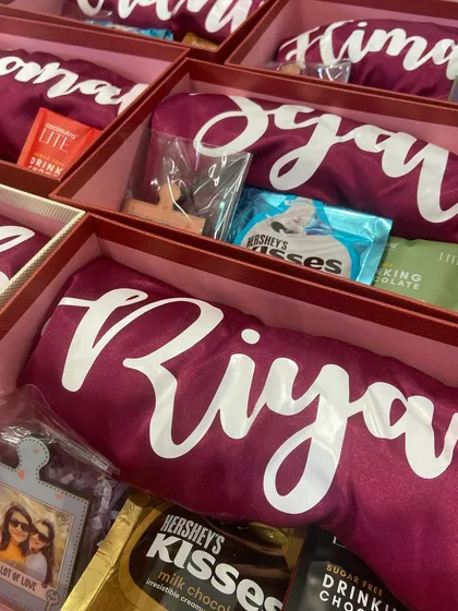 A peek inside our personalized bridesmaid gift boxes. Each one includes a custom-printed robe with the bridesmaid's name, along with chocolates and a small framed photo to make it extra special.