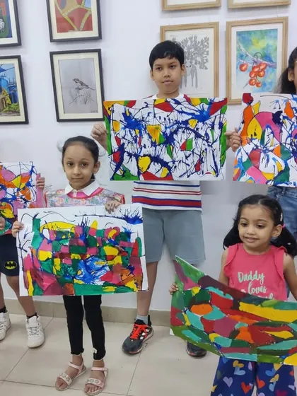 The pure joy of our summer art camp! Here, a group of young creators shows off the colorful abstract paintings they made, building friendships and artistic skills in a fun, supportive environment.