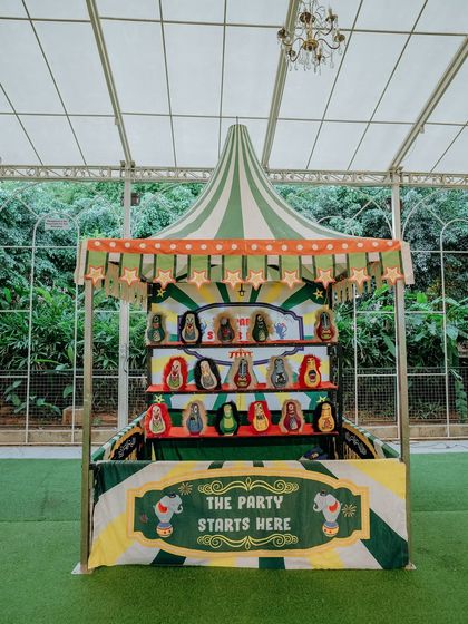 Interactive fun is a key part of my events. This custom-built carnival game stall, with its green and yellow striped awning, provided hours of entertainment for the little guests at the 'Le Cirque Magnifique' birthday.