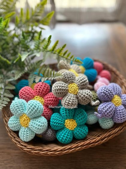 A basket full of our colorful crochet puff flower keychains. They are available in a wide range of colors to match any style.