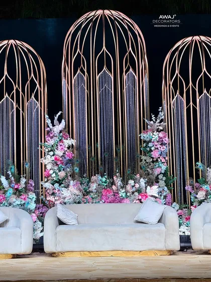 A closer look at the stage's central seating area, showcasing the blend of pastel florals, crystal hangings, and the unique golden architectural elements.