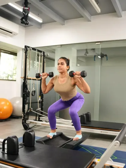 A deep squat with dumbbells, performed with precision and control. This compound exercise works the entire lower body and core, building functional strength for everyday life.