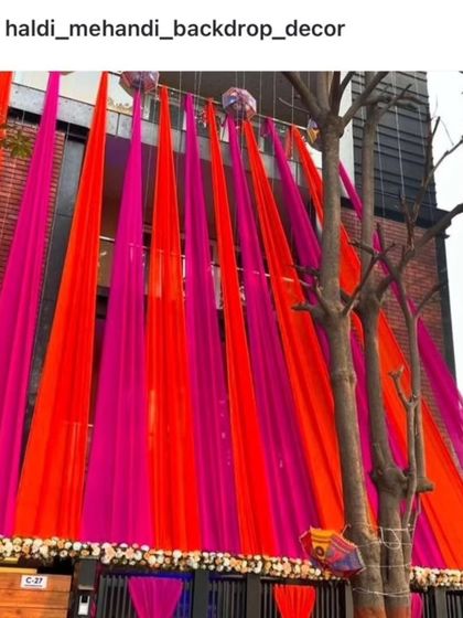 A bold and vibrant house front decoration with bright orange and pink drapes, perfect for making a statement.