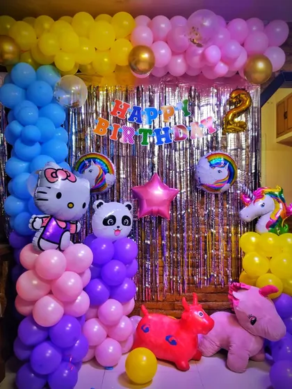 A wider view of the multi-theme birthday party, showing how different character balloons and color schemes can be combined. This setup includes a mix of purple, pink, yellow, and blue balloons to create a playful and eclectic party scene.