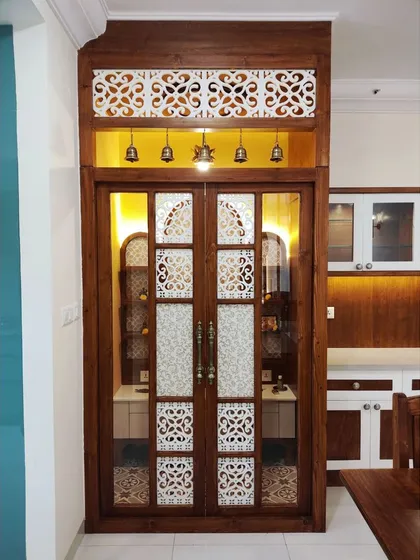 A sacred space, crafted with devotion. This pooja room was designed to be a bridge between the human and the divine, featuring arched niches, intricate jaali work on the doors, and warm backlighting to create an atmosphere of peace and radiance.