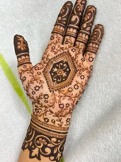A full view of the party henna design, showing the detailed finger work that complements the central pattern.