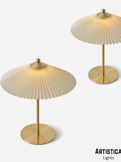 Inspired by classic designs, this table lamp features a beautifully pleated fabric shade that creates a soft, diffused light. The simple metal base provides a modern contrast, making it suitable for a variety of interior styles.
