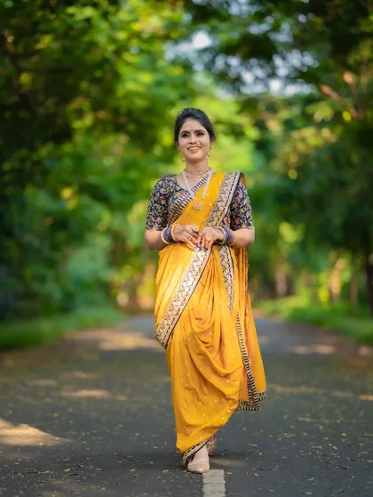 A full view of this graceful Maharashtrian bride in a yellow nauvari. The minimal makeup and messy khopa create a look that is simple yet stunning.