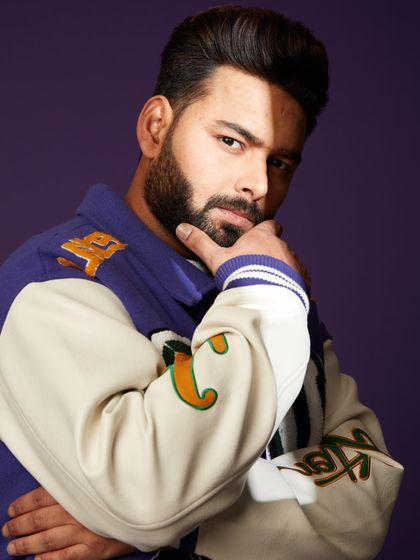 A close-up portrait of Rishabh Pant. The colorful patches and embroidery on the LV jacket add a playful and high-fashion touch.