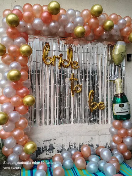 A simple and fun "Bride to be" photo corner, with a rose gold and silver balloon frame and a champagne bottle foil balloon.