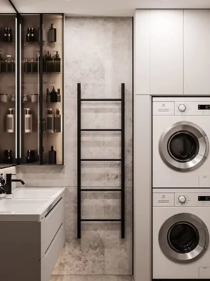 We also design functional utility and laundry spaces. This bathroom includes a stacked washing machine and dryer, along with plenty of storage, all neatly integrated.