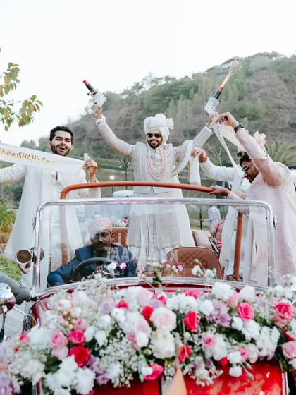 The groom and his squad celebrate with champagne poppers from a vintage car. We plan baraats that are personal, full of life, and incredibly fun.