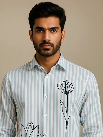 A portrait of the striped shirt with floral line art. The simplicity of the black embroidery against the patterned fabric creates a balanced and elegant design.