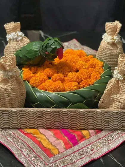I love creating custom gifts. This festive hamper was tailor-made for a client, featuring a charming floral basket made of leaves and filled with marigolds, surrounded by small gift pouches.