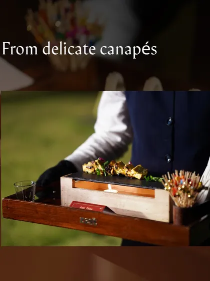 A server presents a tray of delicate canapés, including our mini grilled paneer tikka.