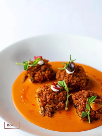 The Achari Artichoke dish, beautifully plated in a rich tomato-based gravy. It's a creative vegetarian option that is full of bold and exciting flavours.
