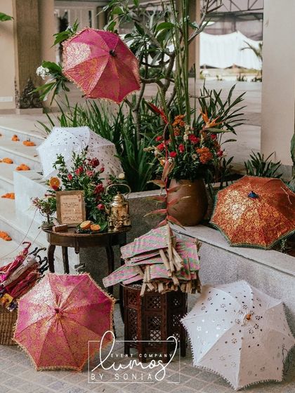 A display of colorful Indian umbrellas for guests to use and take home, a thoughtful and interactive element for a sunny outdoor wedding.