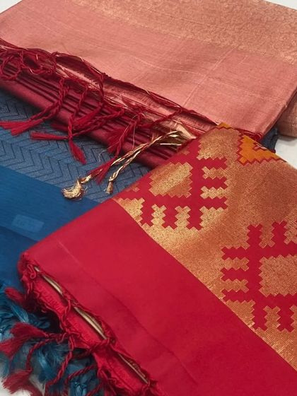 A trio of our handwoven sarees. This flat-lay shows the variety of textures and patterns, from a deep blue chevron to a classic red with a gold brocade border.