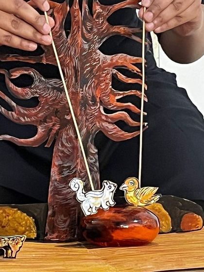 A close-up of a storytelling scene using paper cutout puppets. This style of puppetry is great for illustrating fables and nature stories in our workshops for children.