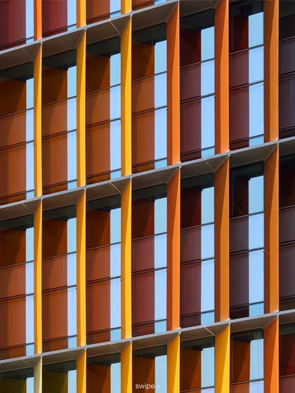 This detailed shot of the facade at the Infosys Nagpur campus shows the precise arrangement of the multi-coloured fins. This system is a key part of the passive cooling strategy, helping the building achieve a 52% reduction in energy use.