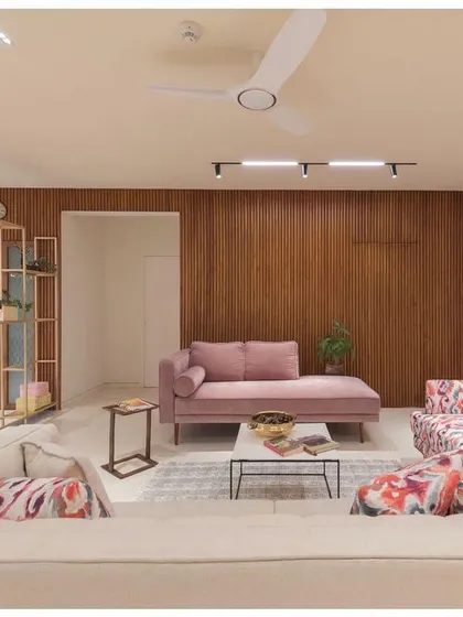 This perspective of the living room shows the sunken seating area and the interplay of different textures and colors. The design uses a metal partition to create a visual barrier to the dining area without closing off the space.