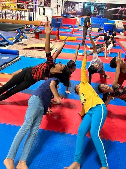 Students engage in a partnered stretching exercise to improve side body length and shoulder mobility. Group stretching adds an element of fun and motivation to our classes.