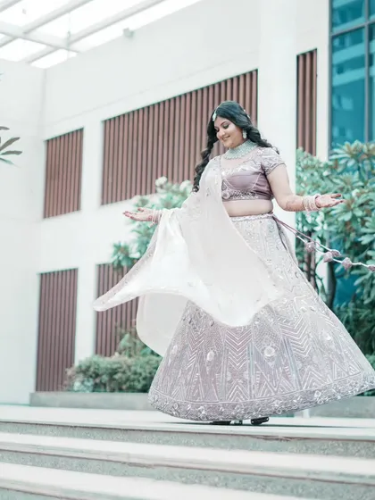 A beautiful full-length shot of the bride twirling in her lavender lehenga, showcasing the flow and detail of her outfit.