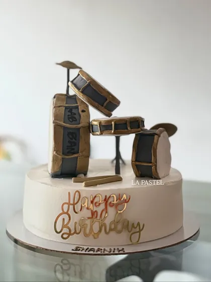 A special cake for a drummer's birthday! I created this miniature edible drum kit with gold and black details, complete with tiny drumsticks. It's a great example of how I can turn your passion into a personalized, delicious cake.