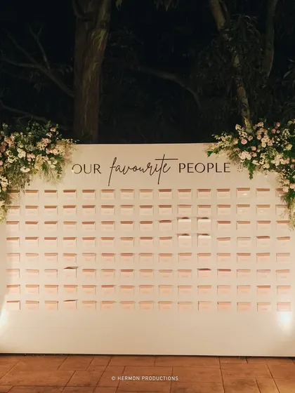 The beautifully lit seating chart wall, a functional piece of decor that adds to the event's sophisticated ambiance.