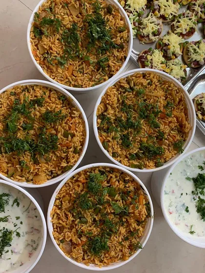 Bowls of Tawa Pulao and Raita for a birthday party.