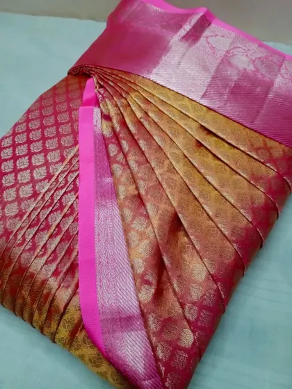 A rich pink and gold silk saree, pleated for a flawless look.