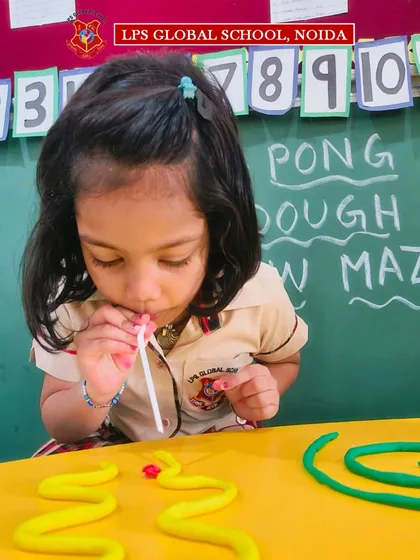 A pre-primary student shows her focus and determination during the ping pong maze game, a perfect example of our play-based learning methodology.