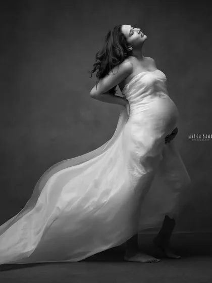 A powerful and emotive pose in black and white. The dramatic lighting from the side highlights every curve, creating a timeless and sculptural piece of art.