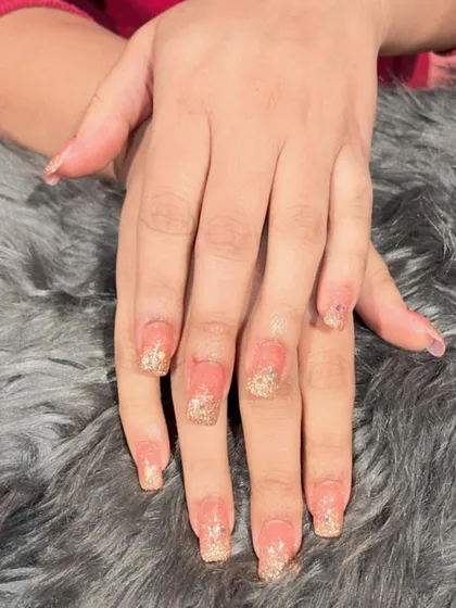 A beautiful gold glitter fade on square-shaped extensions, perfect for adding a touch of glamour to any look.