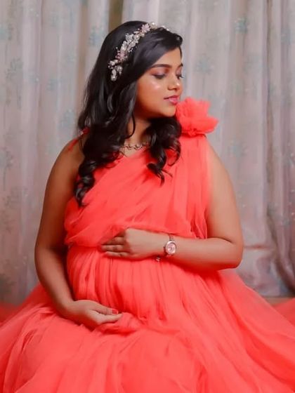 Our coral net gown is incredibly versatile. These studio shots show how it can be styled for elegant, seated portraits, with the fabric creating a soft pool of color.