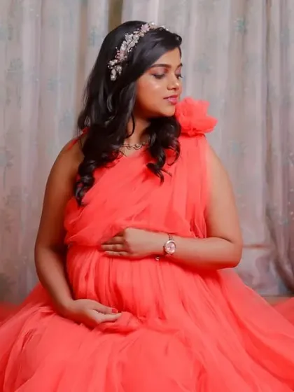 Our coral net gown is incredibly versatile. These studio shots show how it can be styled for elegant, seated portraits, with the fabric creating a soft pool of color.