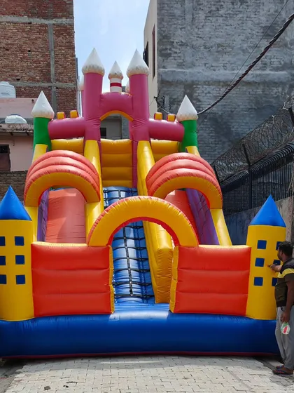 This large castle-themed combo bouncy features multiple towers, two slides, and a central climbing area, all in one impressive structure.