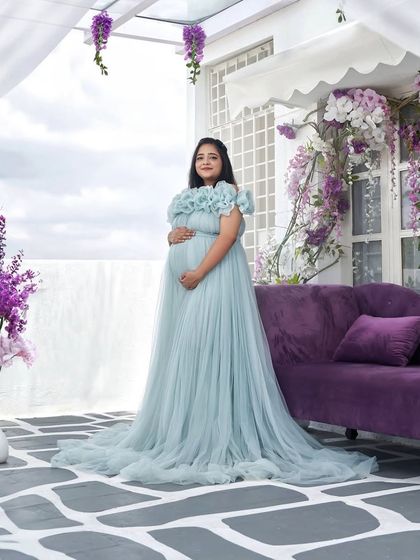 This ice blue gown with its extravagant organza flower neckline is a true showpiece. It creates a stunning, ethereal look against the floral backdrop of this rooftop studio.
