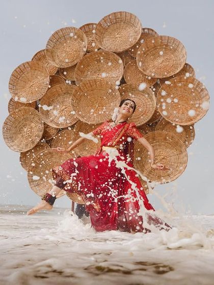 The powerful crash of a wave meets the dynamic pose of the dancer. This image from a creative photoshoot captures a moment of high drama and energy.