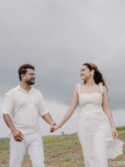 A romantic walking shot of the couple, hand-in-hand in the mountains.