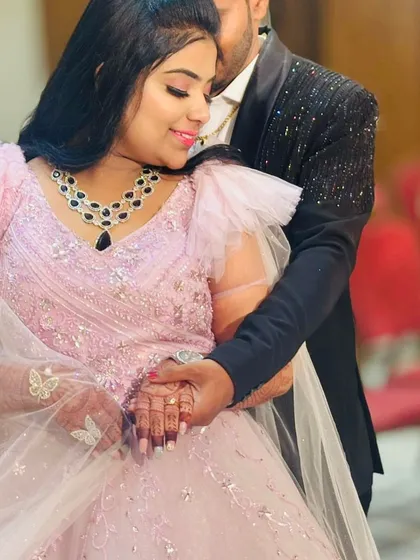 An intimate moment between the engaged couple. This close-up shows the beautiful details of the bride-to-be's pink gown and sparkling black necklace.
