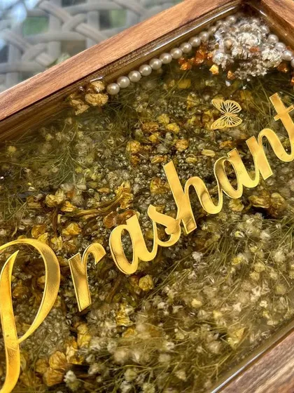 Another close-up of the wooden nameplate, this time showing the name 'Prashant' and the delicate butterfly and pearl details.