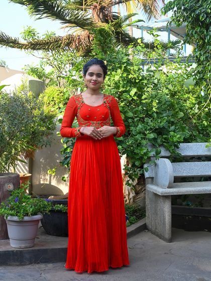 My enchanting client Nisarga looks stunning in this vibrant orange gown. I designed it with a flowing pleated skirt and an intricately embroidered bodice, creating a look of timeless elegance for her special event.