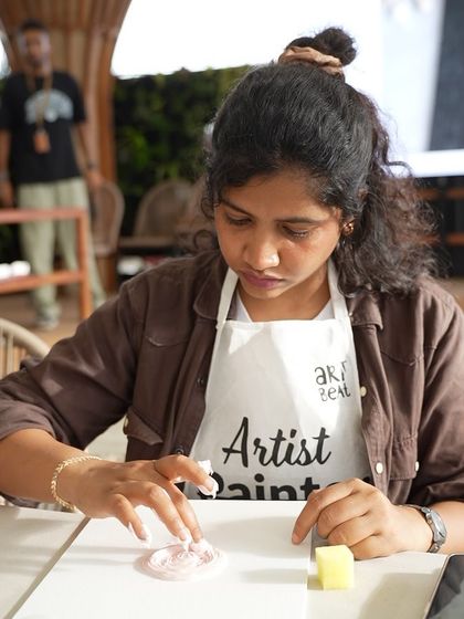 A participant at a corporate event fully engaged in creating her texture art piece. These workshops are a great way to unwind and express creativity.