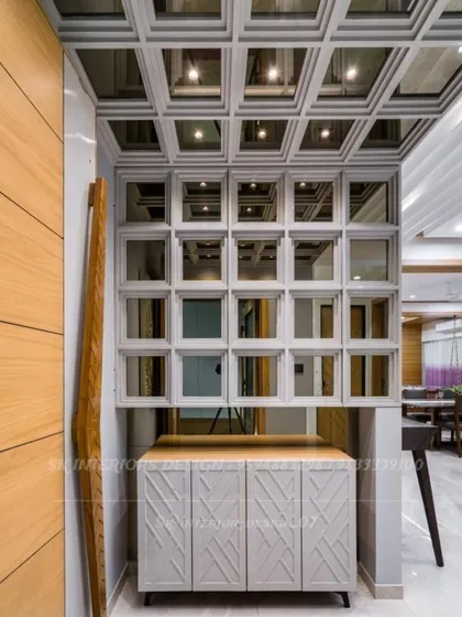 A unique pooja unit or display cabinet with a grid of mirrored niches. This design is perfect for showcasing idols or decorative items in a modern way.