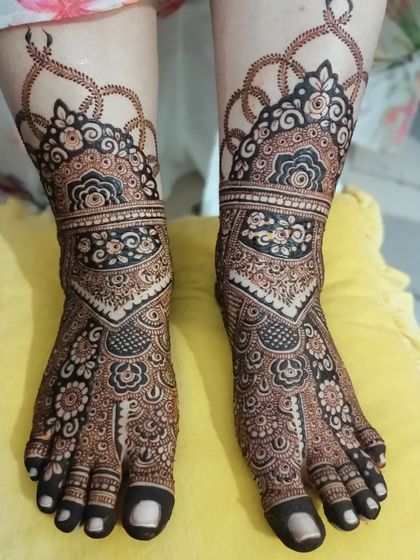A stunningly detailed bridal foot mehendi design. The pattern is intricate and full, featuring a beautiful cuff and patterns extending all the way to the toes.