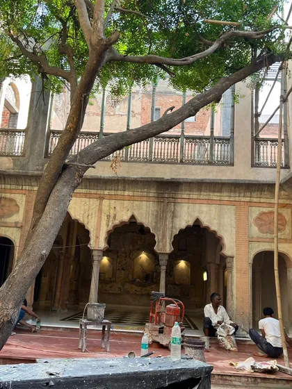 Workers on-site during the restoration of the courtyard, carefully cleaning and preparing the space for its new flooring.