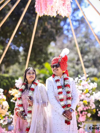 A candid shot of the couple right after their Varmala ceremony, looking out at their guests with happy smiles.